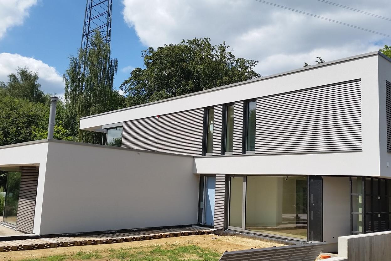 Außenansicht modernes Wohnaus mit weißer Fassade und grauen Elementen